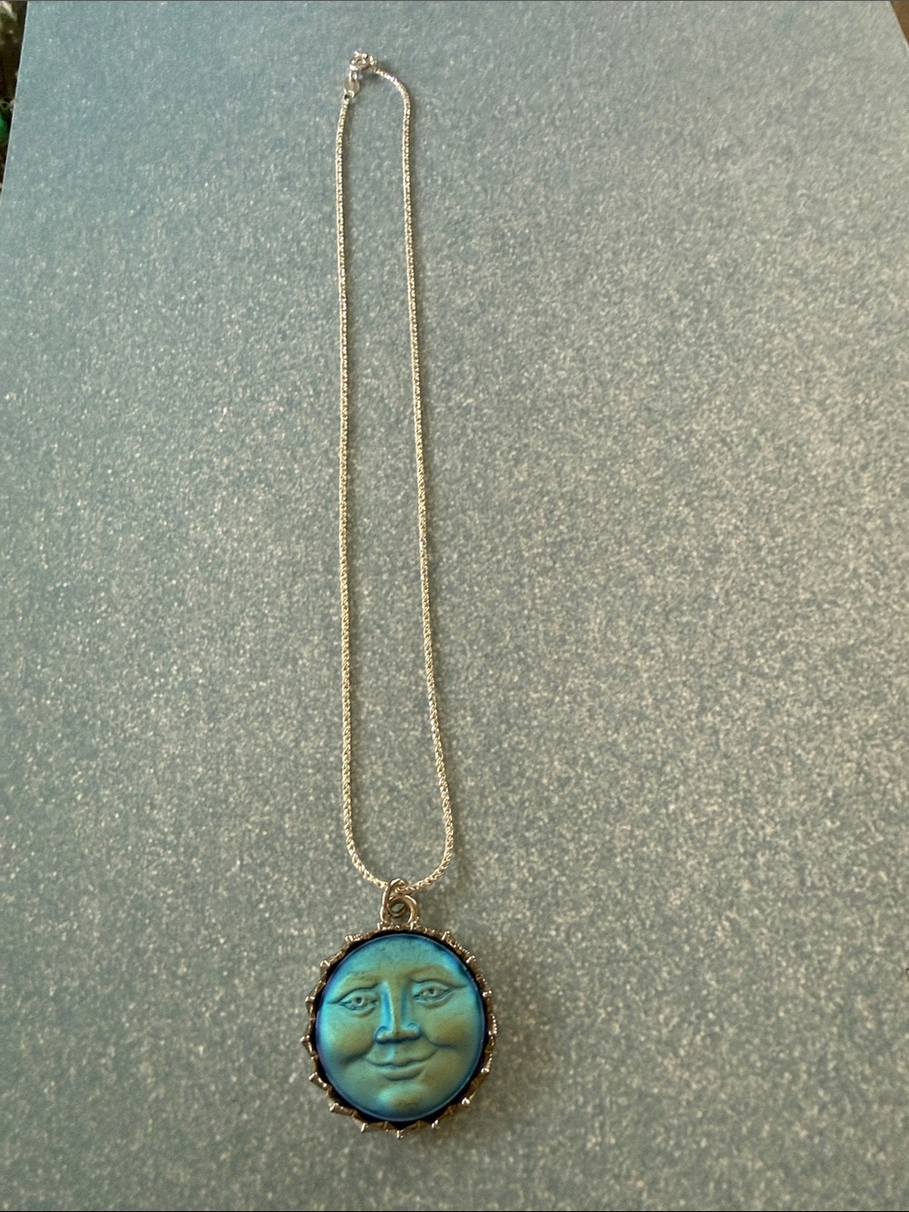 Beautiful Blue Moon Face surrounded by silver on a silver chain.